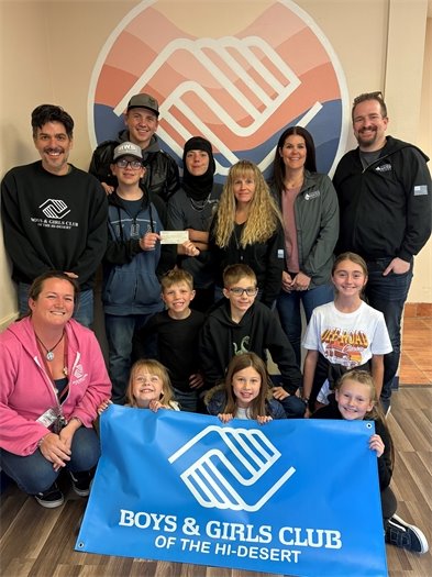 Boys and girls with adults holding a blue Boys And Girls Club banner (jpg)