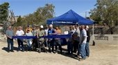 Photo of ribbon cutting at Well 18E people and well site jpg