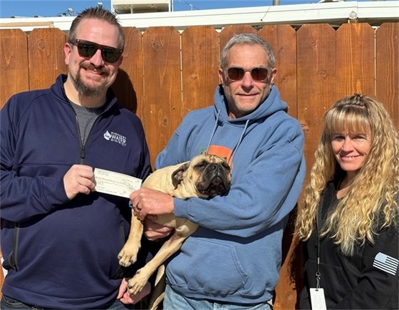 2 men holding a dog and a woman (jpg)